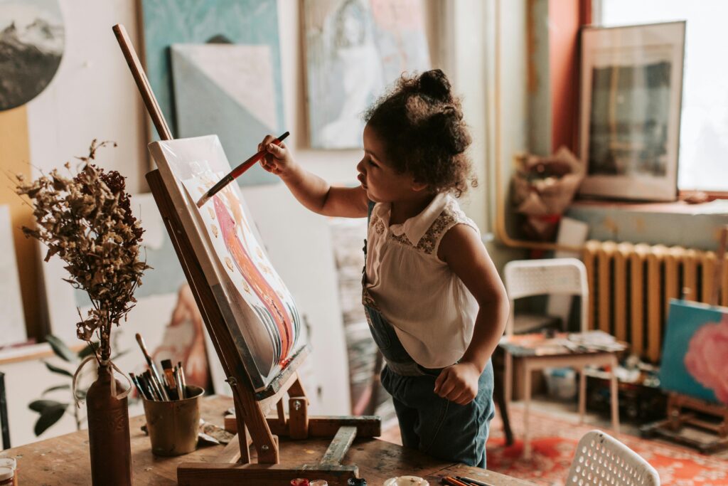 Young girl artistically painting in a cozy indoor art studio, showcasing creativity and expression.